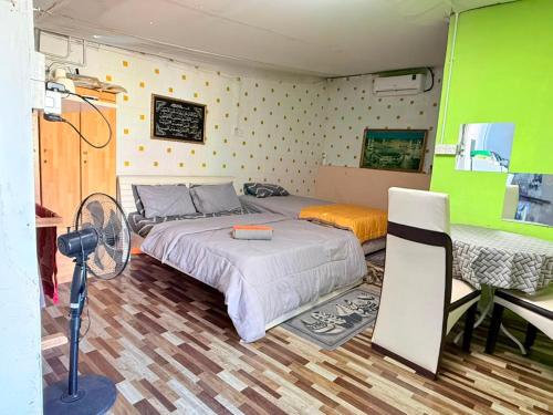 a bedroom with a bed and a fan in it at Dahlia Roomstay Jelai in Gemas