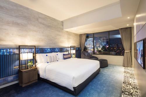 a bedroom with a large bed and a large window at U Nimman Chiang Mai in Chiang Mai
