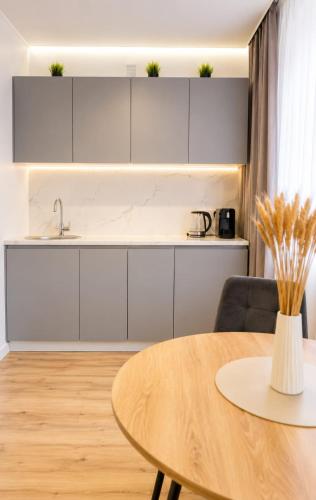 a kitchen with white cabinets and a wooden table at ЖК "Женис III" in Kokshetau