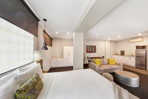 a bedroom with a bed and a living room at Moonlight Bay Apartments in Rye