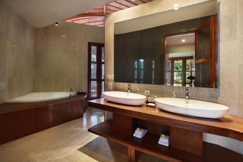 a bathroom with two sinks and a tub and a mirror at Casa Bonita Villa Bali in Jimbaran