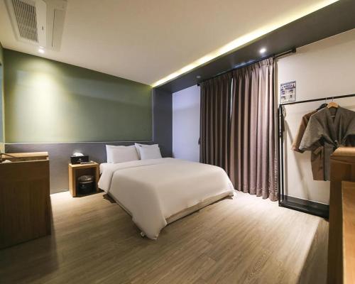 a bedroom with a large white bed and a window at cs프라자호텔 in Cheonan
