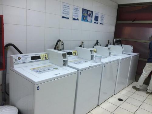 una fila de lavadoras y secadoras en una lavandería en Depto Metro Santa Ana, en Santiago