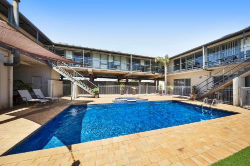 a swimming pool in front of a building at Moonlight Bay Apartments in Rye