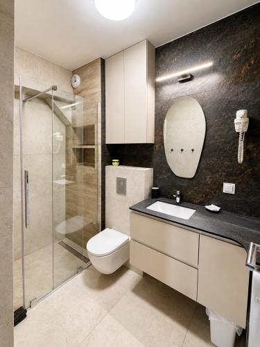 a bathroom with a toilet and a sink and a shower at Apartamenty Lipowa in Puck