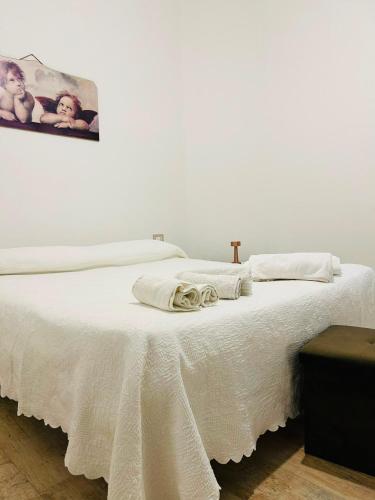 a white bed with two towels on top of it at A casa di Meggie in Dogliola