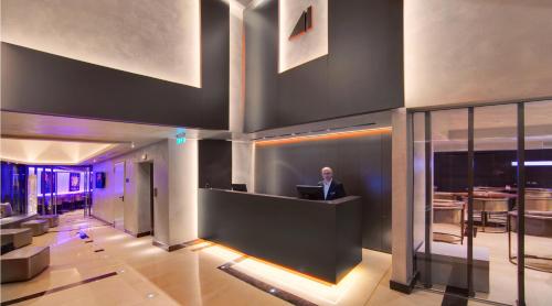 a man sitting at a desk in a lobby with a laptop at SAZ City Life Boutique Hotel in Ioannina
