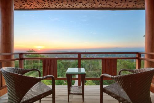 a patio with two chairs and a table on a balcony at Casa Bonita Villa Bali in Jimbaran