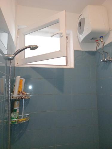 a bathroom with a shower with a window and a shower head at Fumbatown's Finest in Mchamba Wima