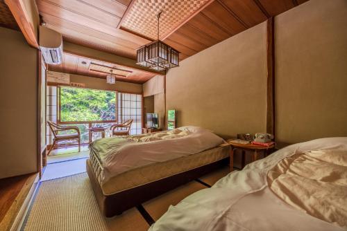 a bedroom with two beds and a table and chairs at Ichinoyu Honkan in Hakone