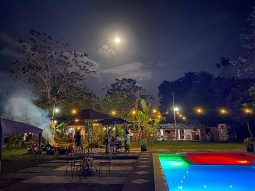 a pool at night with the moon in the sky at Maria Francisca Hometead 