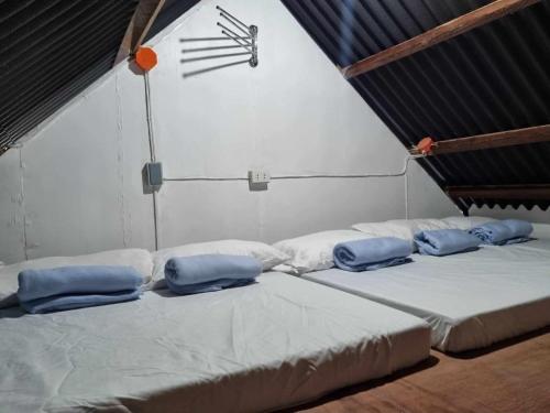 a room with three beds with blue pillows on them at Maria Francisca Hometead 