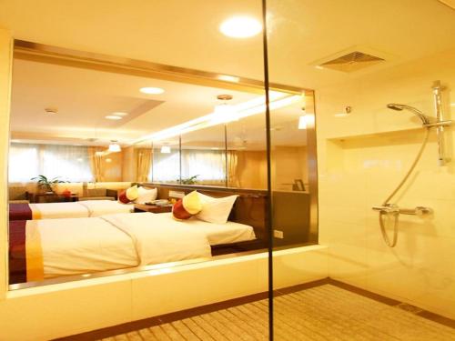 a hotel room with two beds and a shower at New World Hotel in Guangzhou