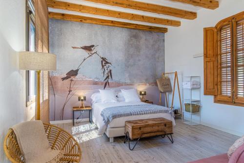 a bedroom with a bed and a wall with birds on it at La Casa del Miracle, hostal in Balaguer