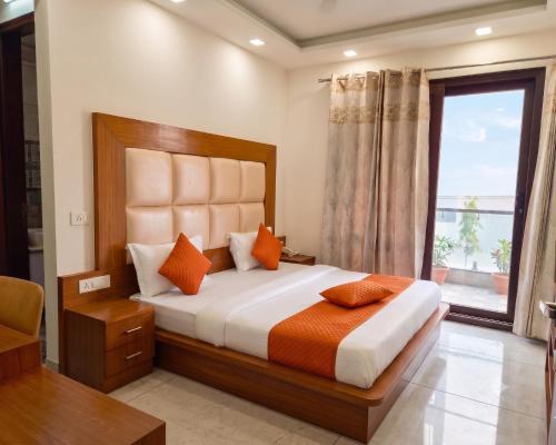 a bedroom with a large bed and a window at Hotel Retro Folic Near Golf Course Road & Cyber City in Gurgaon