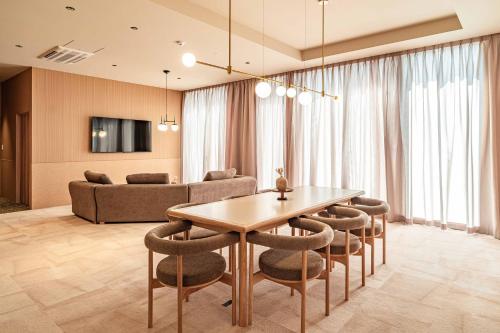 a living room with a table and chairs and a couch at Apartment Hotel 11 Shinsaibashi 9 in Osaka