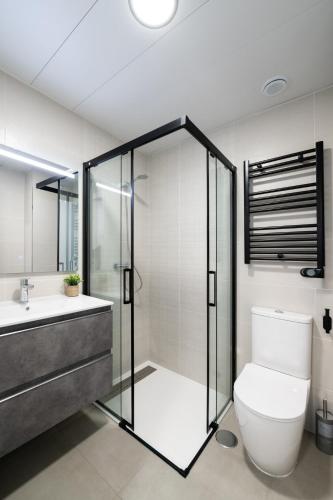 a bathroom with a shower and a toilet and a sink at Getafe Suites in Getafe