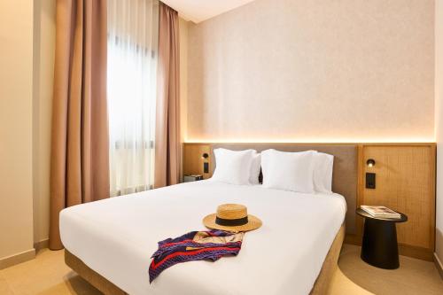 a hotel room with a bed with a hat on it at Ocean Drive Málaga - New Opening 2026 in Málaga