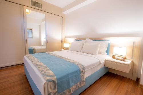 a bedroom with a large bed and a mirror at Heykel Suites Otel in Konak