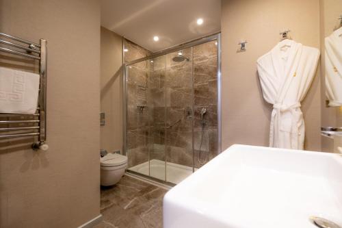 a bathroom with a shower and a toilet at Heykel Suites Otel in Konak