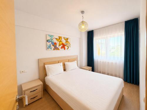 a bedroom with a white bed and a window at Red Hotel Accommodation in Cluj-Napoca