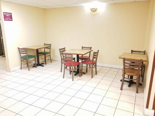 a dining room with wooden tables and chairs at American Inn Evansville East in Evansville