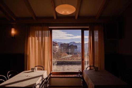 a room with two tables and a large window at Chabarukhi Gudauri Truso in Gudauri