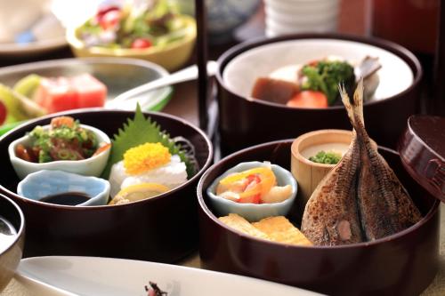 Uminoyasuragi Hotel Ryugu في Kami Amakusa: مجموعة حاويات مليئة بأنواع مختلفة من الطعام