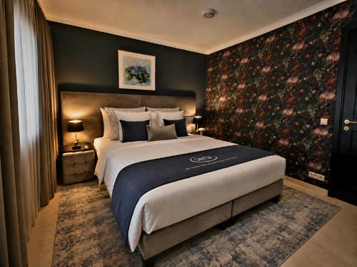 a bedroom with a large bed and a large wall at Wilgenhof Boutique Hotel "volledig vernieuwd en onder nieuw beheer" in Maaseik