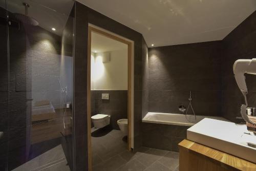 a bathroom with a toilet and a sink and a shower at Hotel Vajolet in San Cassiano