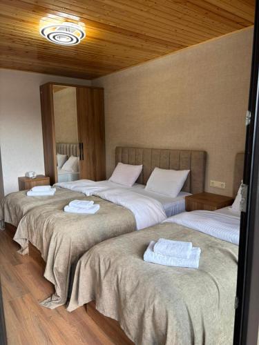 a room with three beds with towels on them at Lalveri INN in Mestia