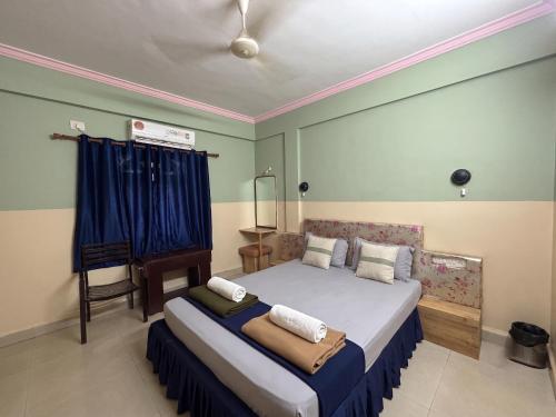 a bedroom with a bed with blue and green walls at FabHotels Fiora in Pune