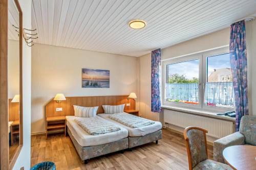 a hotel room with a bed and a couch at Hotel Zum Wikinger - Haustiere in Dornum