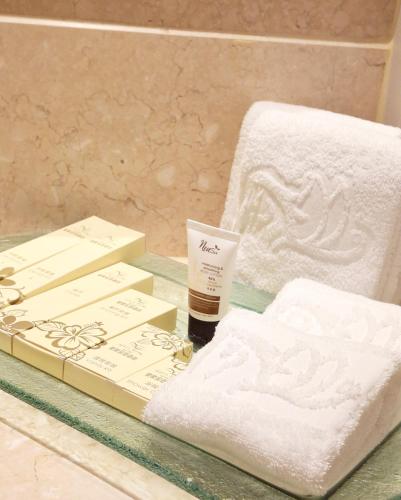 a glass table with towels and a bottle of soap at Casa Real Hotel in Macau
