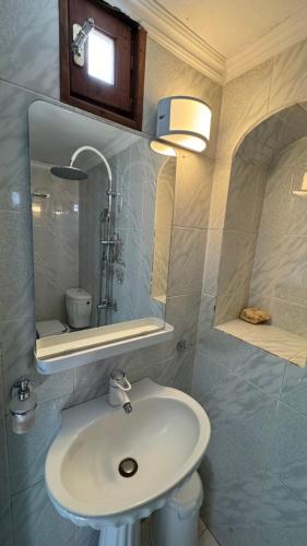 a bathroom with a sink and a mirror at Kamares in Tholária