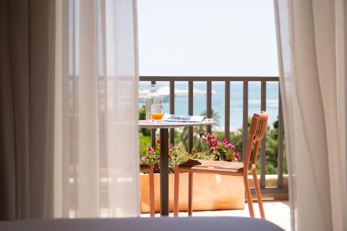 a table with a glass of wine on a balcony at Ocean Drive Málaga - New Opening 2026 in Málaga