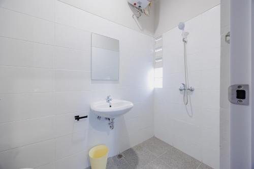 a white bathroom with a sink and a shower at Sans Stay Bintaro in Pondoklang