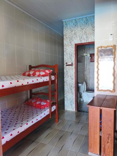 a room with two bunk beds and a bathroom at Casa beira mar com piscina Coruripe Povoado Miai de cima in Coruripe