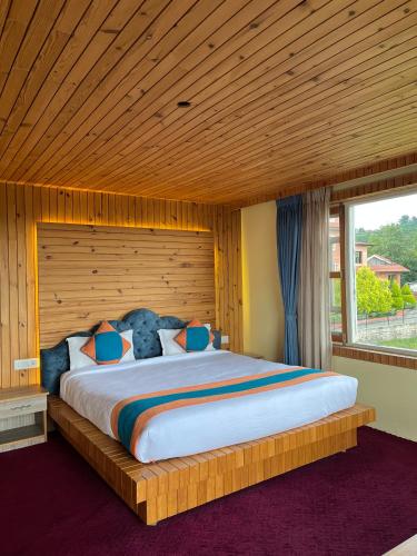 a bedroom with a large bed with a wooden ceiling at Landmark Diamond Hill in Panaoti