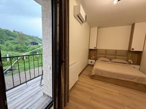 a bedroom with a bed and a balcony at Black sea batumi in Chakvi