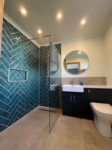 a bathroom with a toilet and a sink and a mirror at Crofters Cottage Barra 