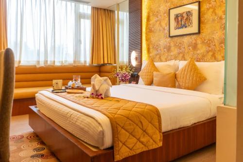 a hotel room with a large bed and a window at Regenta Orkos Kolkata by Royal Orchid Hotels Limited in Kolkata