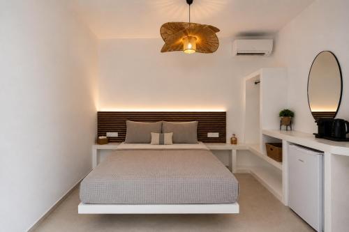 a white bedroom with a bed and a mirror at Danа̃e Sun&Sea Stays in Livadi