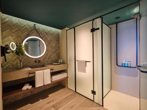 a bathroom with a shower and a mirror at Novotel Dhahran Hotel & Residences in Dhahran
