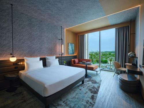 a hotel room with a bed and a large window at Novotel Dhahran Hotel & Residences in Dhahran