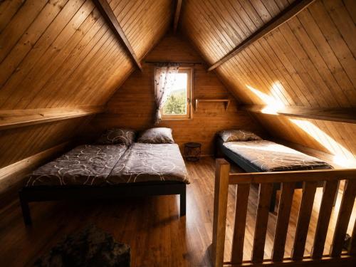 a room with two beds in a wooden cabin at Chata Nikki in Vrbno pod Pradědem