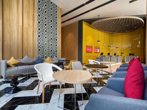 a lobby with couches and tables and chairs at ibis Bangkok Sukhumvit 24 in Bangkok