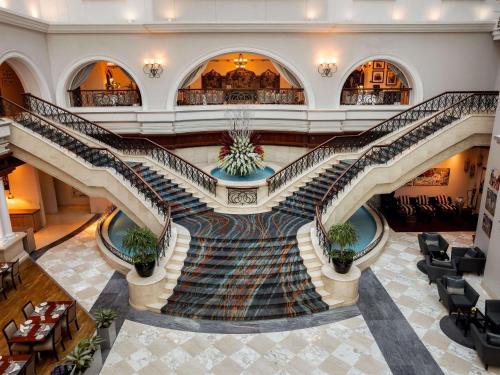 a spiral staircase in a building with potted plants at Mövenpick Hotel & Apartments Bur Dubai in Dubai