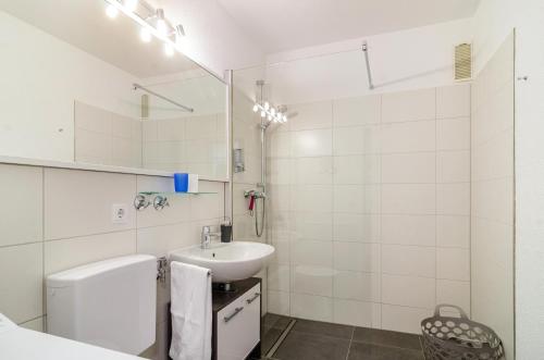 a white bathroom with a sink and a mirror at Ferienwohnung Alex in Meersburg