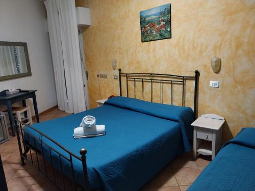a bedroom with a blue bed with a tray on it at Hotel Carol & Residence Grazia in Rimini